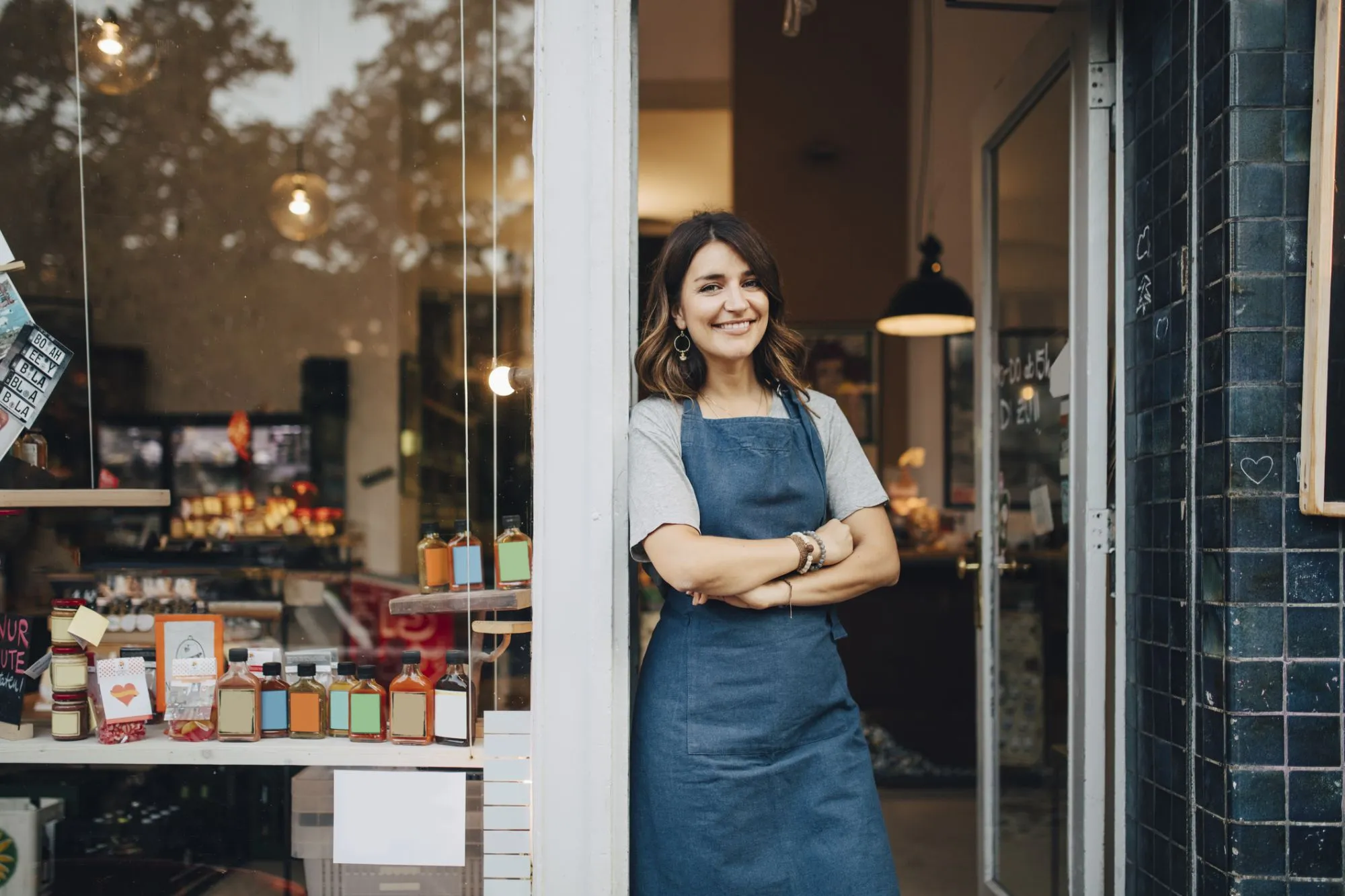 Small business owner standing at the doorway of her shop